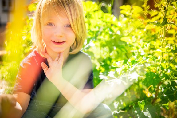Junge zwischen Pflanzen in warmem Licht