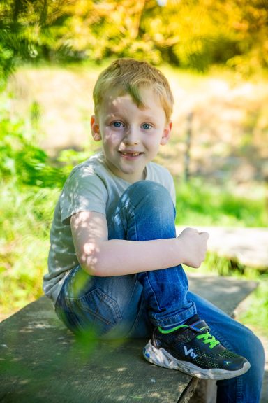 Freundlich lächelnder Junge sitzend