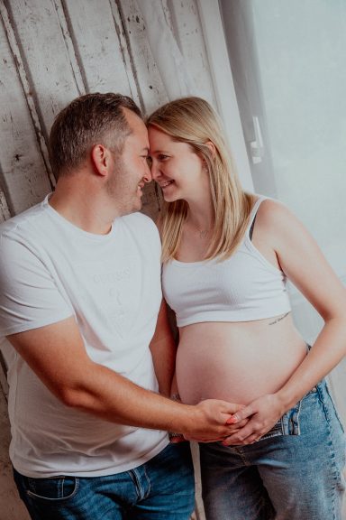 Ein Paar umarmt sich liebevoll, während die Frau schwanger ist.